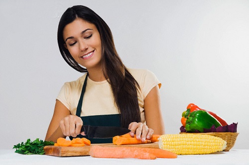 Close-up of a woman cutting vegetables --- Image by © Glowimages/Corbis